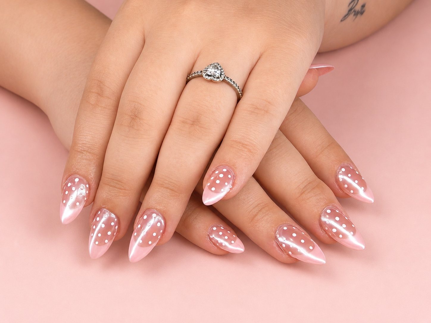 Stiletto nails in sheer pearl pink dotted with tiny white polka dots